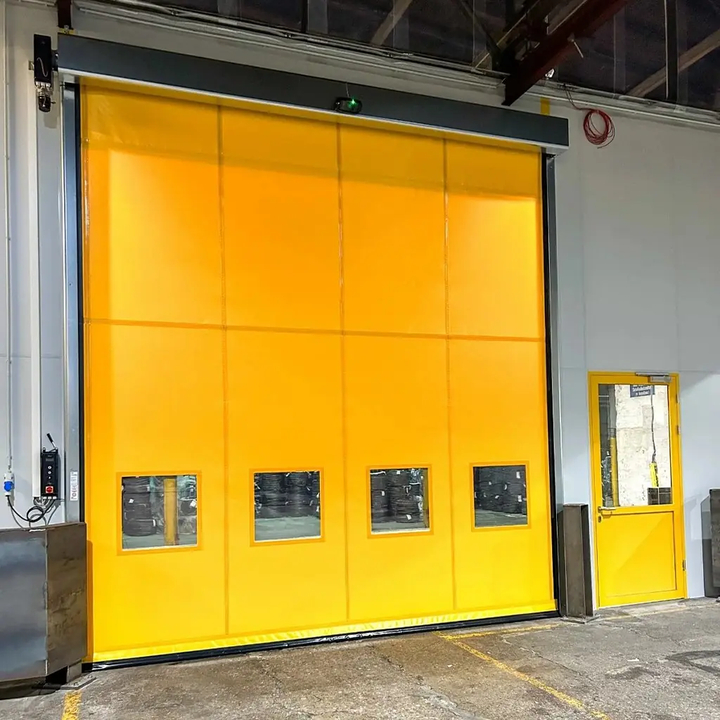 Gelbes PVC-Schnelllauftor in Industriehalle mit Sichtfenstern, professionell eingebaut